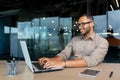 Young successful Indian programmer working inside modern development company, man using laptop to write code for Royalty Free Stock Photo