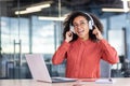 Young successful joyful woman working inside office with laptop, female programmer listening to music, singing along and Royalty Free Stock Photo