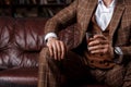 young successful man in a brown kosmtyum drinks whiskey. bearded businessman sitting in a library on a luxurious leather Royalty Free Stock Photo