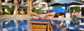 Young and successful man lying on a sun lounger at the hotel on the background of sunset. Panoramic banner landscape header. Relax Royalty Free Stock Photo