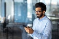 Young successful mature businessman inside the office using the phone, man holding a smartphone online application user Royalty Free Stock Photo