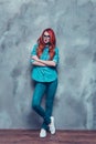 Young successful red head foxy young lady is standing on grey b