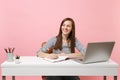 Young successful woman looking aside writing notes on notebook sit, work at white desk with contemporary pc laptop Royalty Free Stock Photo