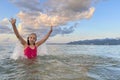 Young summer girl in pink swimsuit having fun in sea with water splash. Happy child on beach in sea on summer holidays Royalty Free Stock Photo