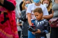 A young Superhero plays with his action figures while protesters wear PPE Face Masks at a Black Lives Matter protest in Richmond,