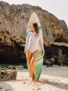 Young surf girl with surfboard poising at beach. Surfer woman standing at beach. Royalty Free Stock Photo