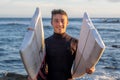 Young surfer comes out of the water carrying the broken board in the middle. Handsome guy with wetsuit. Horizon over the water