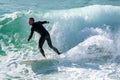 Young surfer enjoys the waves confronting the surf by surfing the rougher waters after a morning rain storm Royalty Free Stock Photo