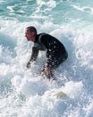 Young surfer enjoys the waves confronting the surf by surfing the rougher waters after a morning rain storm