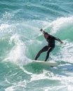 Young surfer enjoys the waves confronting the surf by surfing the rougher waters after a morning rain storm Royalty Free Stock Photo