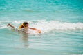 Young surfer, happy young girl in the ocean on surfboard. Kid learn to surf with board. Royalty Free Stock Photo