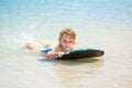 Young surfer, happy young boy in the ocean on surfboard. Royalty Free Stock Photo