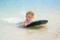 Young surfer, happy young boy in the ocean on surfboard. Royalty Free Stock Photo