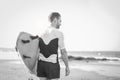 Young surfer holding his surfboard on the beach - Handsome man waiting waves for surfing - Black and white editing Royalty Free Stock Photo