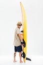 Young surfer holding surfboard and looking over his shoulder Royalty Free Stock Photo