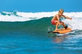 Young surfer learn to ride on surfboard on sea waves