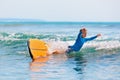 Young surfer learning ride and fall from surfboard with fun