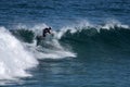 A young surfer re-enters the crest of a wave