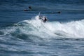 A young surfer re-enters the crest of a wave