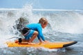 Young surfer rides on surfboard with fun on sea waves Royalty Free Stock Photo