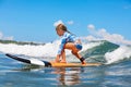 Young surfer rides on surfboard with fun on sea waves Royalty Free Stock Photo