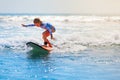 Young surfer rides on surfboard with fun on sea waves