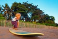 Young surfer stand on surfboard with fun on sunset beach