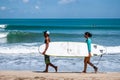 Young surfers holding a surf board