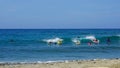 Young surfers raffle the waves of a Caribbean beach on a beautiful sunny day Royalty Free Stock Photo