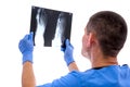 Young surgeon examining an x-ray image foot of the patient isolated on white background