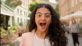 Young surprised amazed excited woman Indian Arabian female girl outside. Positive businesswoman shock smiling open mouth Royalty Free Stock Photo