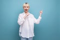 young surprised blond career woman in white shirt on blue background with copy space. people lifestyle concept Royalty Free Stock Photo