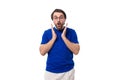 young surprised confident caucasian brunette man with a beard and glasses in a blue t-shirt on a white background