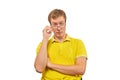 Young surprised man looking over his glasses, man in yellow T-shirt isolated on white background Royalty Free Stock Photo
