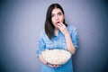 Young surprised woman eating popcorn