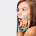 Young surprised woman holding a turquoise bracelet