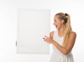 Young surprised woman showing presentation, pointing on placard.