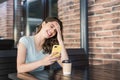 Young surprised woman using smart phone at cafe. Excited student girl texting on mobile phone. Royalty Free Stock Photo