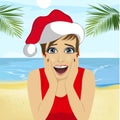 Young surprised woman wearing santa hat on beach, christmas theme Royalty Free Stock Photo