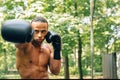 Young sweated boxer performing shadow boxing