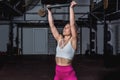 Young sweaty muscular strong fit girl holding big heavy barbell weight plate with her hands and lifting it up as hardcore cross wo Royalty Free Stock Photo