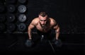 Young sweaty strong fit muscular man with big muscles doing push ups on the dumbbells in the gym hardcore cross workout training Royalty Free Stock Photo