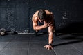 Young sweaty strong and fit muscular man push ups workout with touching his shoulder on one hand in the gym on the floor Royalty Free Stock Photo