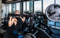 Young sweaty strong muscular fit bodybuilder man back muscles workout training with weights on the machine in the gym Royalty Free Stock Photo