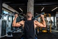 Young sweaty strong muscular fit bodybuilder man back muscles workout training with weights on the machine in the gym Royalty Free Stock Photo