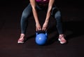 Young sweaty strong muscular fit girl hands holding heavy kettlebell on the floor concentrating and preparing for hardcore cross