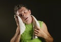 Young sweaty tired and exhausted sport man drying sweat after hard fitness workout at gym club isolated on black background in