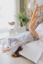 Young sweet girl is lying on bed with her legs raised Royalty Free Stock Photo