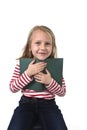 Young sweet little 6 or 7 years old with blond hair girl holding book smiling happy