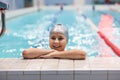 Young swimmer girl. Portrait of ten years old Caucasian athlete in swimming cap in pool